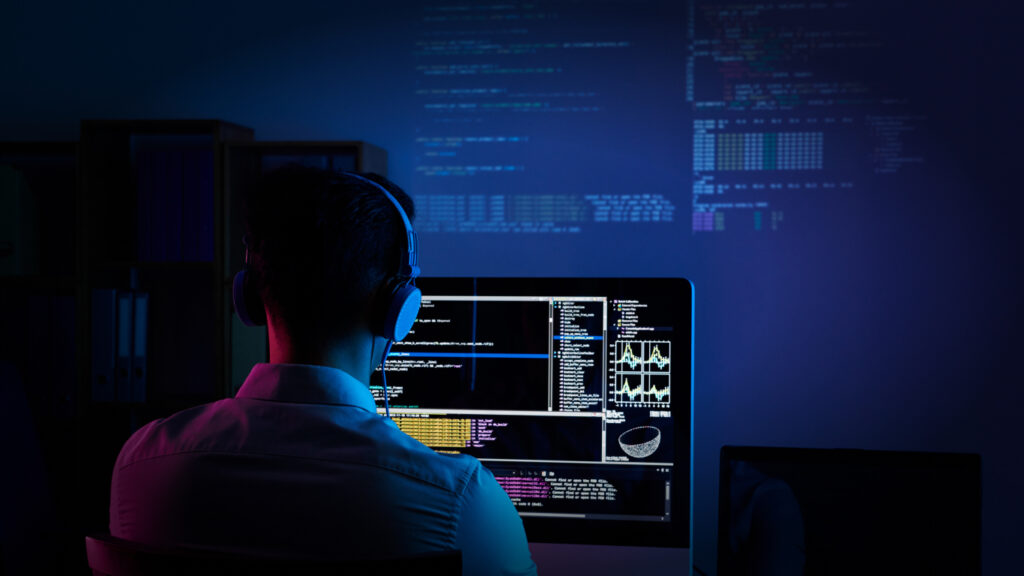 Software developer working on complex code and data visualization screens in a modern office, representing custom web development company services including tailored website design, advanced web application development, scalable digital solutions, and cutting-edge technology integration to help businesses maximize online growth, user engagement, and long-term digital success.